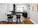 Beautiful kitchen with black countertops and modern black and white cabinetry, plus a breakfast bar with stools at 4850 Guilford Ave, Indianapolis, IN 46205