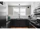 Modern kitchen featuring white cabinets, stainless steel appliances, and a stylish light fixture over the sink at 4850 Guilford Ave, Indianapolis, IN 46205