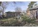 Image of the yard with grass, bare trees, a swing set, a small shed and a home with gray siding at 5110 Chelsea Rd, Indianapolis, IN 46241