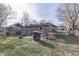 View of the backyard with a gray home exterior, bare trees, a grill, and a small brick patio at 5110 Chelsea Rd, Indianapolis, IN 46241