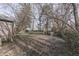 A partial view of the yard with sparse grass, and bare trees and a partial view of the house at 5110 Chelsea Rd, Indianapolis, IN 46241