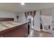 Serene bedroom featuring a dark bed frame, inviting natural light, a wood-look floor, and access to an additional room at 5110 Chelsea Rd, Indianapolis, IN 46241