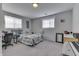 Bright bedroom with two windows, soft gray carpet, a desk, and minimal decor that creates a cozy, minimalist space at 5110 Chelsea Rd, Indianapolis, IN 46241