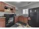 Functional kitchen featuring wood cabinets, black appliances, and checkered flooring at 5110 Chelsea Rd, Indianapolis, IN 46241