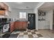 Well-lit kitchen with wood cabinets, black appliances, and a view to the laundry area at 5110 Chelsea Rd, Indianapolis, IN 46241