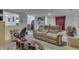 Inviting living room featuring a plush tan reclining sofa, neutral carpet, and open layout to the kitchen and laundry area at 5110 Chelsea Rd, Indianapolis, IN 46241