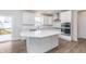Modern kitchen featuring white cabinets, stainless steel appliances, an island and a door leading to an outdoor deck at 5314 Noble Crossing W Pkwy, Noblesville, IN 46062