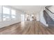 Spacious living area with laminate floors, large windows, and a staircase at 5314 Noble Crossing W Pkwy, Noblesville, IN 46062