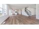Open-concept living area featuring laminate flooring, large windows, and a staircase at 5314 Noble Crossing W Pkwy, Noblesville, IN 46062