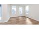 Sunlit living room features laminate flooring, three windows, and white trim at 5314 Noble Crossing W Pkwy, Noblesville, IN 46062