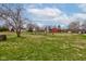 Expansive backyard featuring a large grassy area and several mature trees for shade at 5902 Sunset Dr, Indianapolis, IN 46239