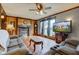 Cozy living room featuring a fireplace, wood paneling, hardwood floors, and a large window with exterior view at 5902 Sunset Dr, Indianapolis, IN 46239
