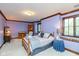 Comfortable bedroom featuring a bed, sitting area, hardwood trim, and ample natural light at 6010 Fawnwood Dr, Greenwood, IN 46143