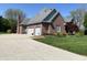 Brick home with a three-car garage and a long driveway at 6010 Fawnwood Dr, Greenwood, IN 46143