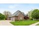 Beautiful brick home with a three-car garage, well-kept lawn, and mature trees at 6010 Fawnwood Dr, Greenwood, IN 46143