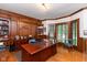 Sophisticated home office with custom wood paneling, built-in bookshelves, and large desk at 6010 Fawnwood Dr, Greenwood, IN 46143