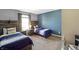Stylish bedroom with two twin beds, wooden headboards, and a serene blue accent wall at 6615 School Branch Dr, Brownsburg, IN 46112