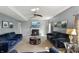 Large living room with fireplace, neutral walls, ceiling fan and comfortable navy upholstered seating at 6615 School Branch Dr, Brownsburg, IN 46112