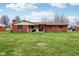 Exterior of home featuring a brick facade and a spacious backyard at 6905 E Hanna Ave, Indianapolis, IN 46203
