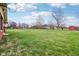 Expansive backyard featuring lush green grass and a variety of trees at 6905 E Hanna Ave, Indianapolis, IN 46203