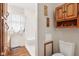 Cozy bathroom featuring shower, commode, and vanity, accented with a floral wallpaper pattern at 6905 E Hanna Ave, Indianapolis, IN 46203