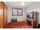 Bedroom featuring red carpet, a built-in desk, and a window with floral curtains at 6905 E Hanna Ave, Indianapolis, IN 46203