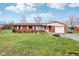 Charming single-story brick home with a well-manicured front lawn and an attached one-car garage at 6905 E Hanna Ave, Indianapolis, IN 46203