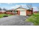 Cozy brick home with attached garage and paved driveway leading up to the charming entrance at 6905 E Hanna Ave, Indianapolis, IN 46203