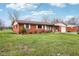 Quaint single-story brick home featuring a green lawn, attached garage, and a welcoming facade at 6905 E Hanna Ave, Indianapolis, IN 46203