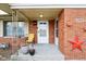 Close-up of the red brick facade featuring a covered porch with decorative accents at 6905 E Hanna Ave, Indianapolis, IN 46203