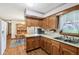 Well-lit kitchen with wood cabinets, stainless steel sink, and a charming view of the outdoors at 6905 E Hanna Ave, Indianapolis, IN 46203
