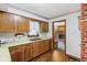 Functional kitchen featuring wood cabinets, double sink, and a glimpse into the cozy living area at 6905 E Hanna Ave, Indianapolis, IN 46203