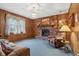 Inviting living room featuring a classic brick fireplace, wood paneling, and comfortable furnishings at 6905 E Hanna Ave, Indianapolis, IN 46203