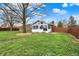 Exterior view of the home featuring a sunroom, spacious yard, and mature trees at 6958 W Brier Creek Dr, New Palestine, IN 46163