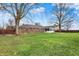 This home features a brick exterior, green lawn, and a large tree for shade in the backyard at 6958 W Brier Creek Dr, New Palestine, IN 46163