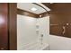 A brown-toned bathroom featuring a shower-tub combo and a sliding shower door at 6958 W Brier Creek Dr, New Palestine, IN 46163