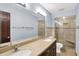 Bathroom featuring double sinks, a large mirror, and a tiled shower with a glass door at 6958 W Brier Creek Dr, New Palestine, IN 46163