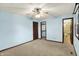 Bedroom with neutral carpet, light blue walls, ceiling fan, and a doorway to the bathroom at 6958 W Brier Creek Dr, New Palestine, IN 46163