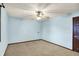 Bedroom with neutral carpet, light blue walls, ceiling fan and a dark brown door at 6958 W Brier Creek Dr, New Palestine, IN 46163