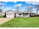 Well-maintained single-story home with an attached garage, lush green lawn, and a prominent American flag at 6958 W Brier Creek Dr, New Palestine, IN 46163
