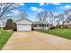 Inviting single-story home with a spacious driveway, green lawn, and charming covered front porch at 6958 W Brier Creek Dr, New Palestine, IN 46163
