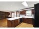 Open concept kitchen showcasing an island with generous counter space and dark wood cabinets at 6958 W Brier Creek Dr, New Palestine, IN 46163