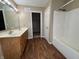 Bathroom featuring double vanity sinks, tub/shower combo and adjacent walk-in closet at 7130 English Birch Ln, Indianapolis, IN 46268