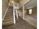 Inviting foyer with stairs leading up, adjacent to carpeted living spaces, perfect for entertaining at 7130 English Birch Ln, Indianapolis, IN 46268