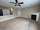 Spacious living room features neutral carpet, ceiling fan, and a cozy fireplace at 7130 English Birch Ln, Indianapolis, IN 46268