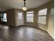 A bright, open living room with wood floors, large windows, and a stylish light fixture at 7130 English Birch Ln, Indianapolis, IN 46268