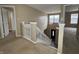 Carpeted stairway with white railings overlooking the front door and adjacent living space at 7130 English Birch Ln, Indianapolis, IN 46268