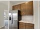 Modern kitchen featuring stainless steel refrigerator, wood cabinets, and white subway tile backsplash at 7170 Rose Hill Ave, Brownsburg, IN 46112