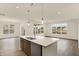 Open-concept kitchen with quartz island, stainless appliances, and hardwood floors throughout the home at 7170 Rose Hill Ave, Brownsburg, IN 46112