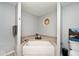 Bathroom with a built-in bathtub, neutral walls, and natural lighting at 7347 Blue Creek S Dr, Indianapolis, IN 46256